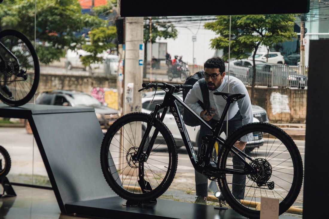 Cliente conhecendo uma bike Sense na vitrine da S2 Bike Shop Montes Claros
